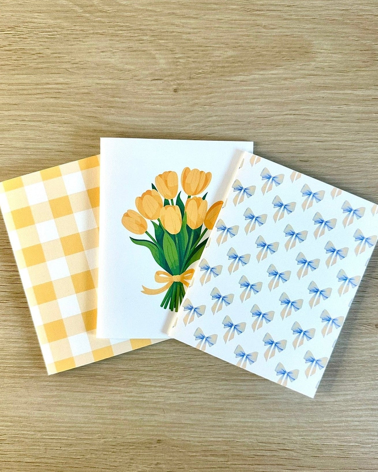 Three greeting cards with different designs on a wooden surface