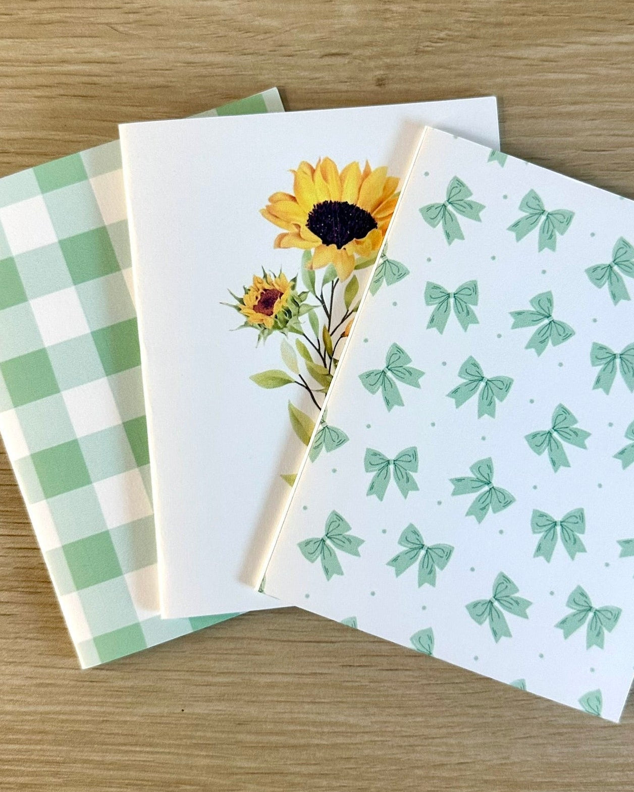 Three greeting cards with different designs on a wooden surface