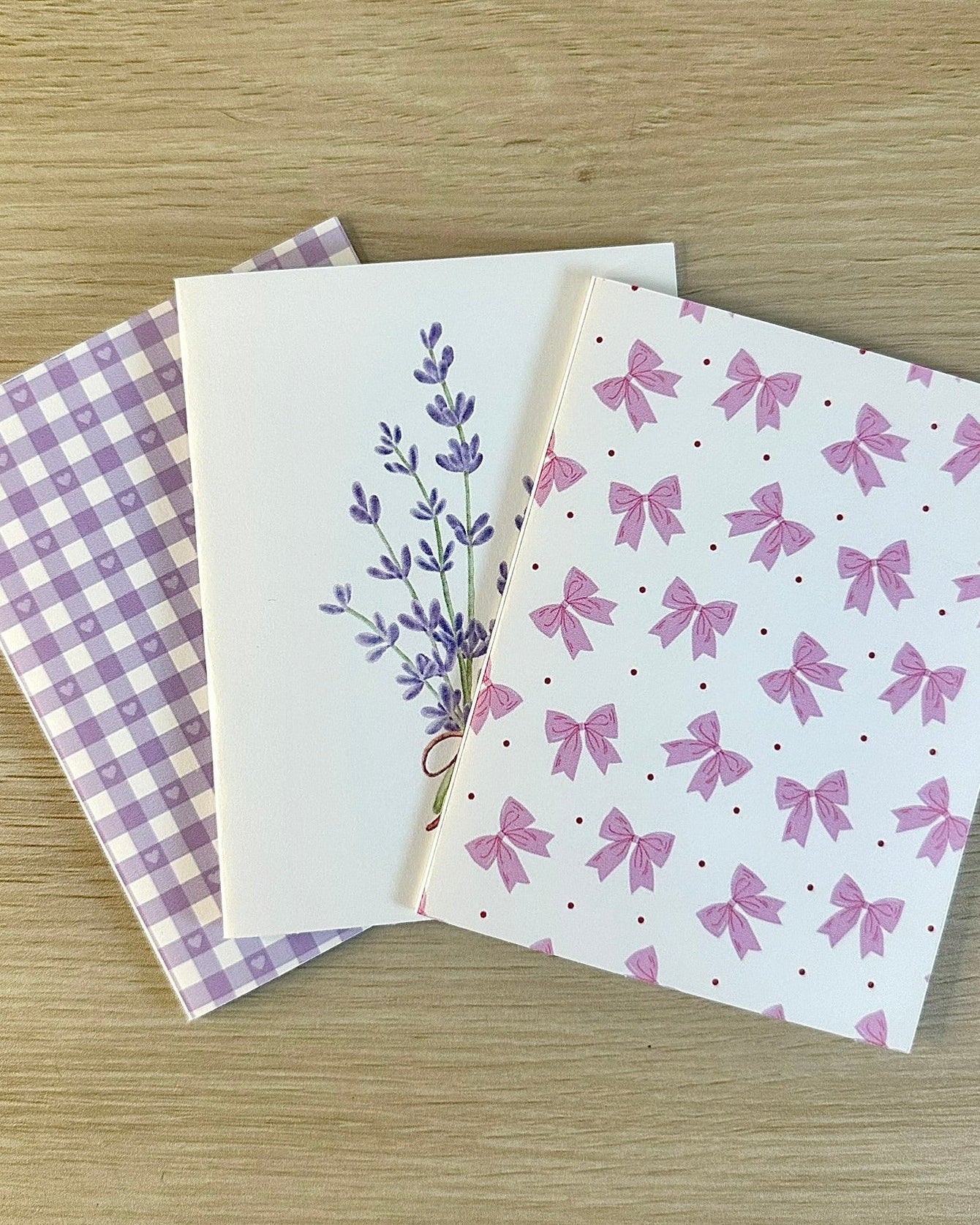 Three greeting cards with different designs on a wooden surface