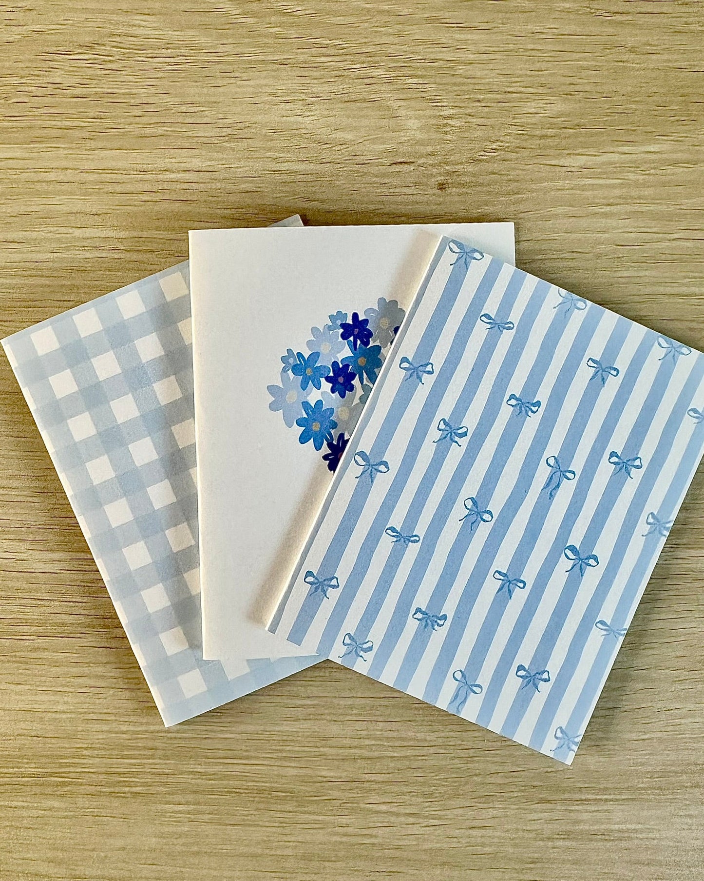 Three blue greeting cards on a wooden surface